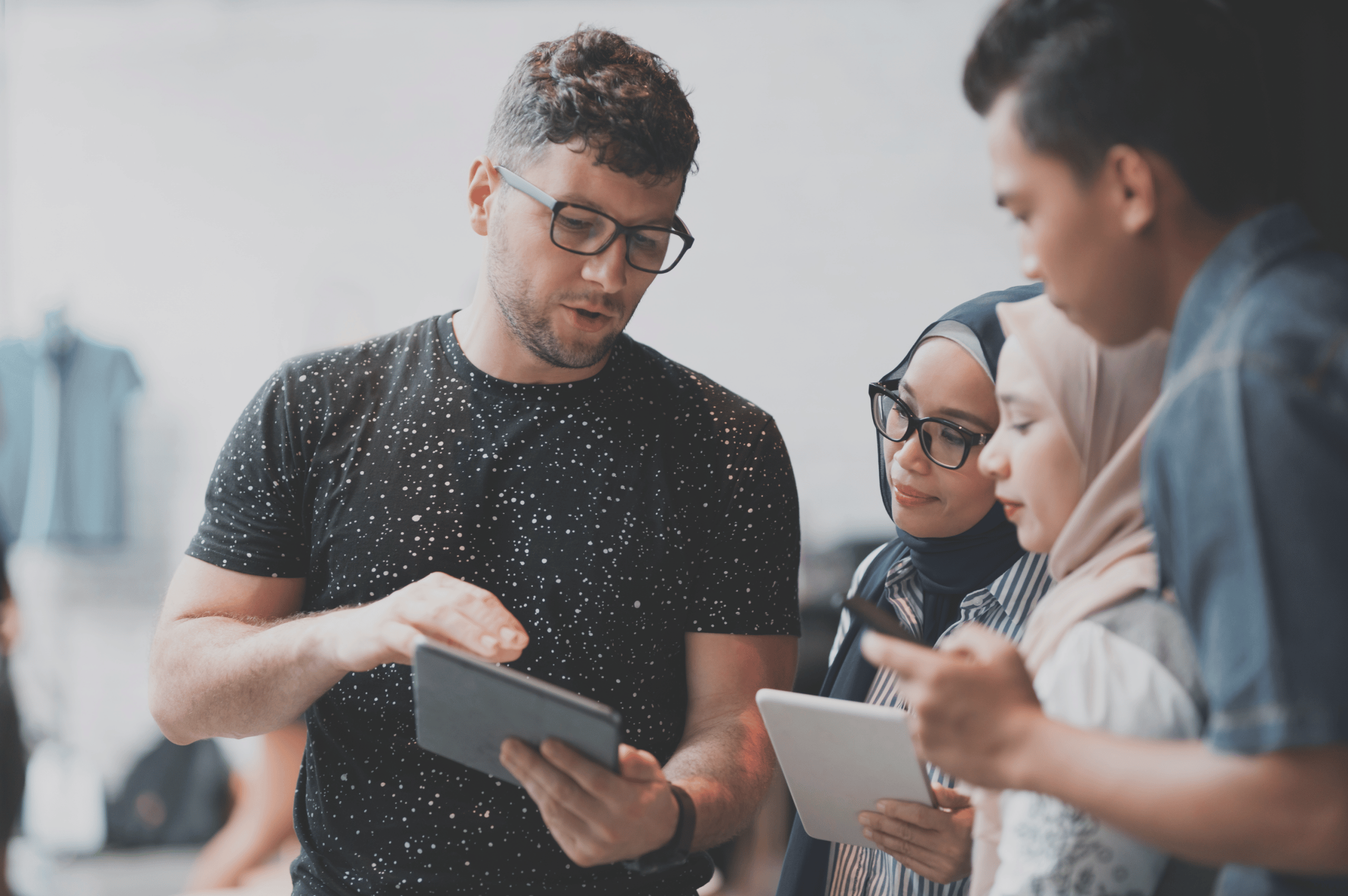 Man explaining something on his tablet to people. » admin by request