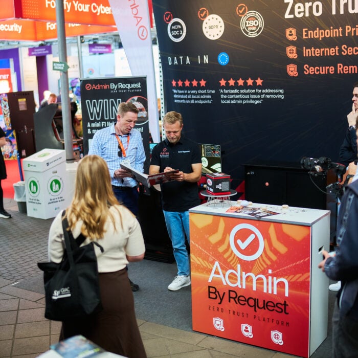 Exhibition booth for admin by request with staff showing materials at a tech trade show. » admin by request