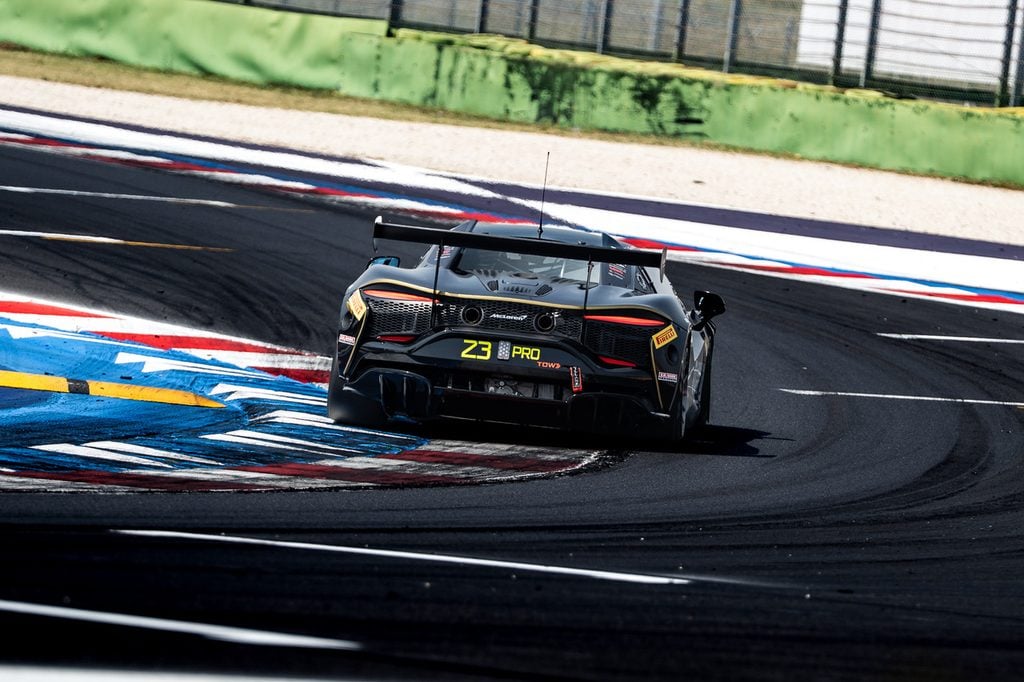 Luca misano 1 » admin by request Black race car #23 on a racing track taking a sharp left turn at a corner, rear view with large spoiler. » admin by request