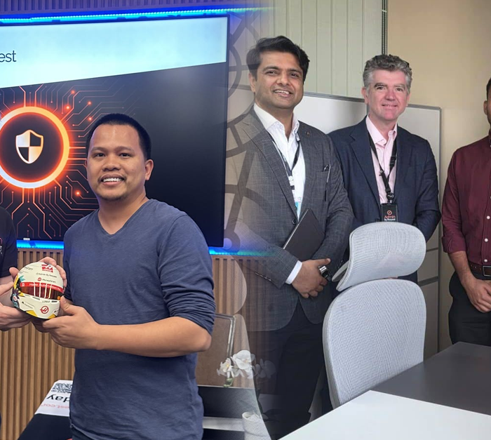Two men exchange a small branded ball trophy in an office event, with a large 'admin by request' screen behind them and colleagues nearby. » admin by request