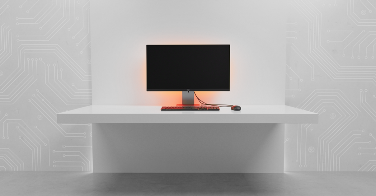 White desk with a black monitor, red keyboard and mouse, and an orange backlight against a circuit-pattern wall.