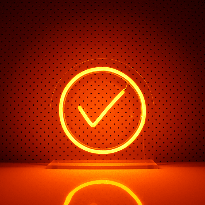 A photo of a lit up orange neon admin by request sign with a dotted background. » admin by request