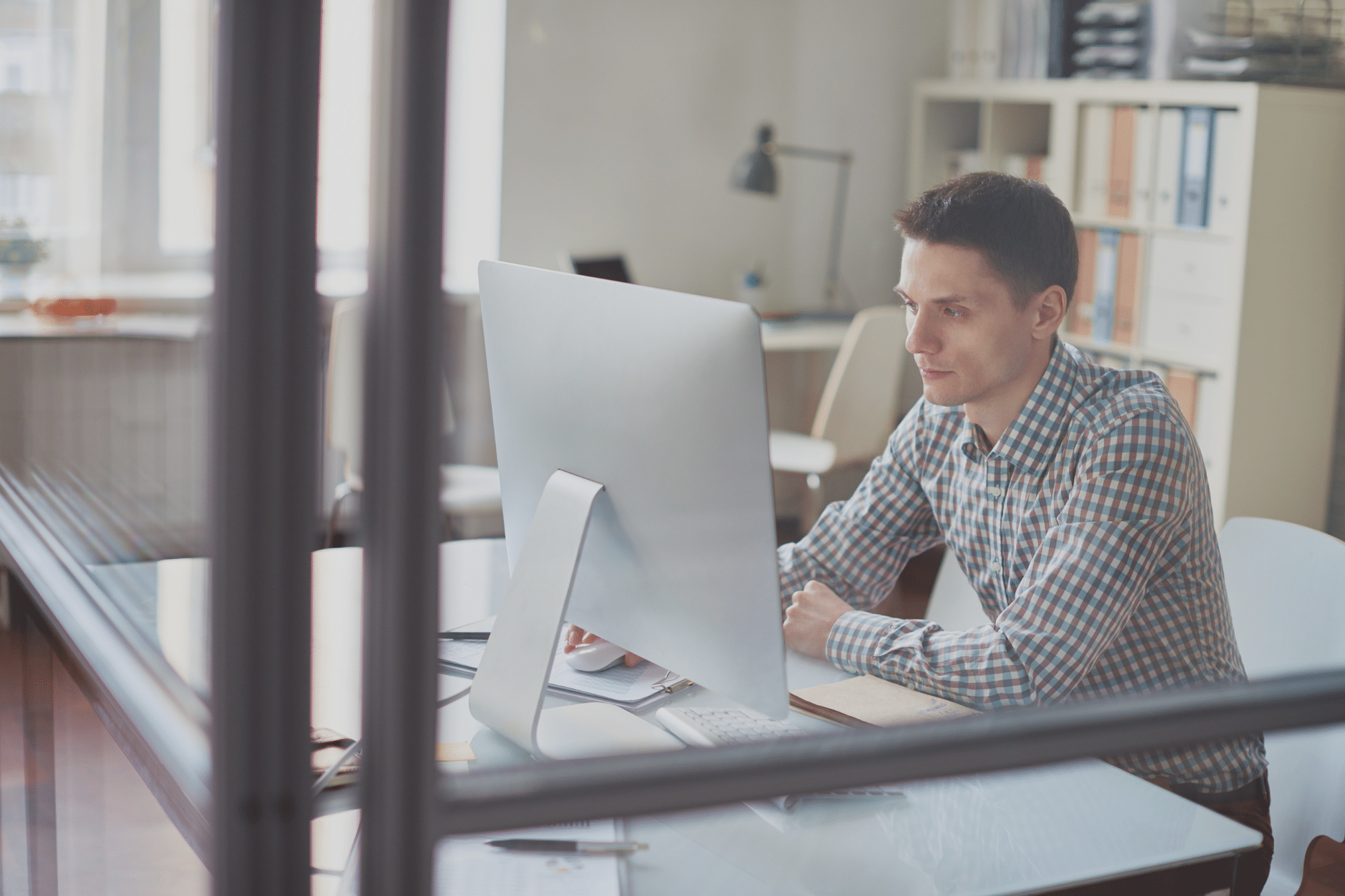 A man in a checkered shirt using his mac. » admin by request » admin by request