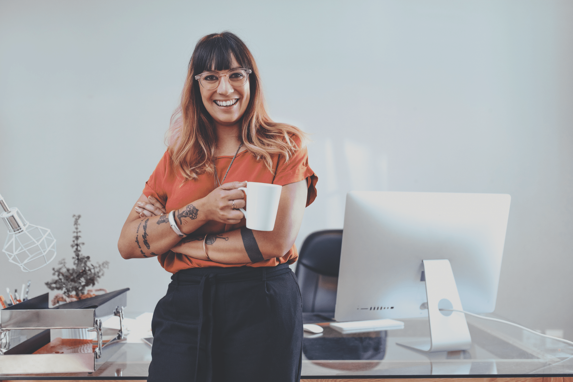 Meet global compliance requirements. Smiling woman holding a cup of coffee, leaning against her workdesk. » admin by request