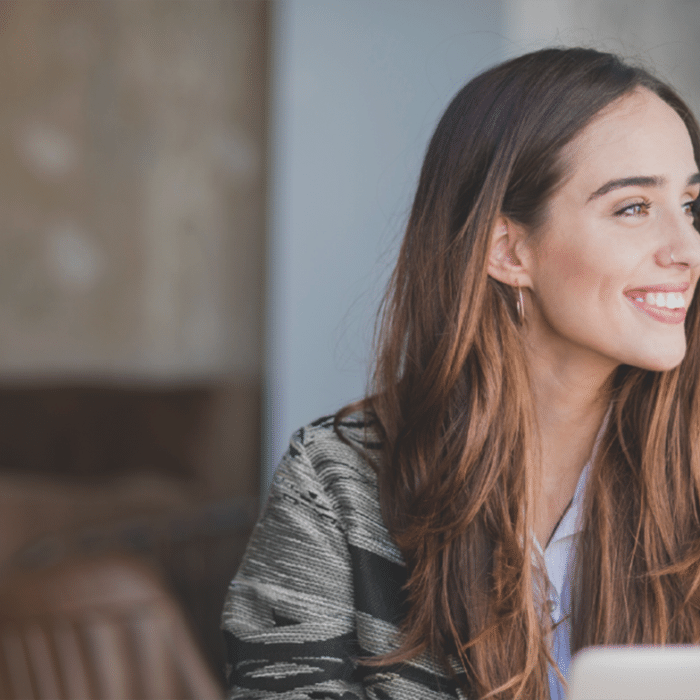 A woman who is sitting at her computer desk smiling to the right side. » admin by request