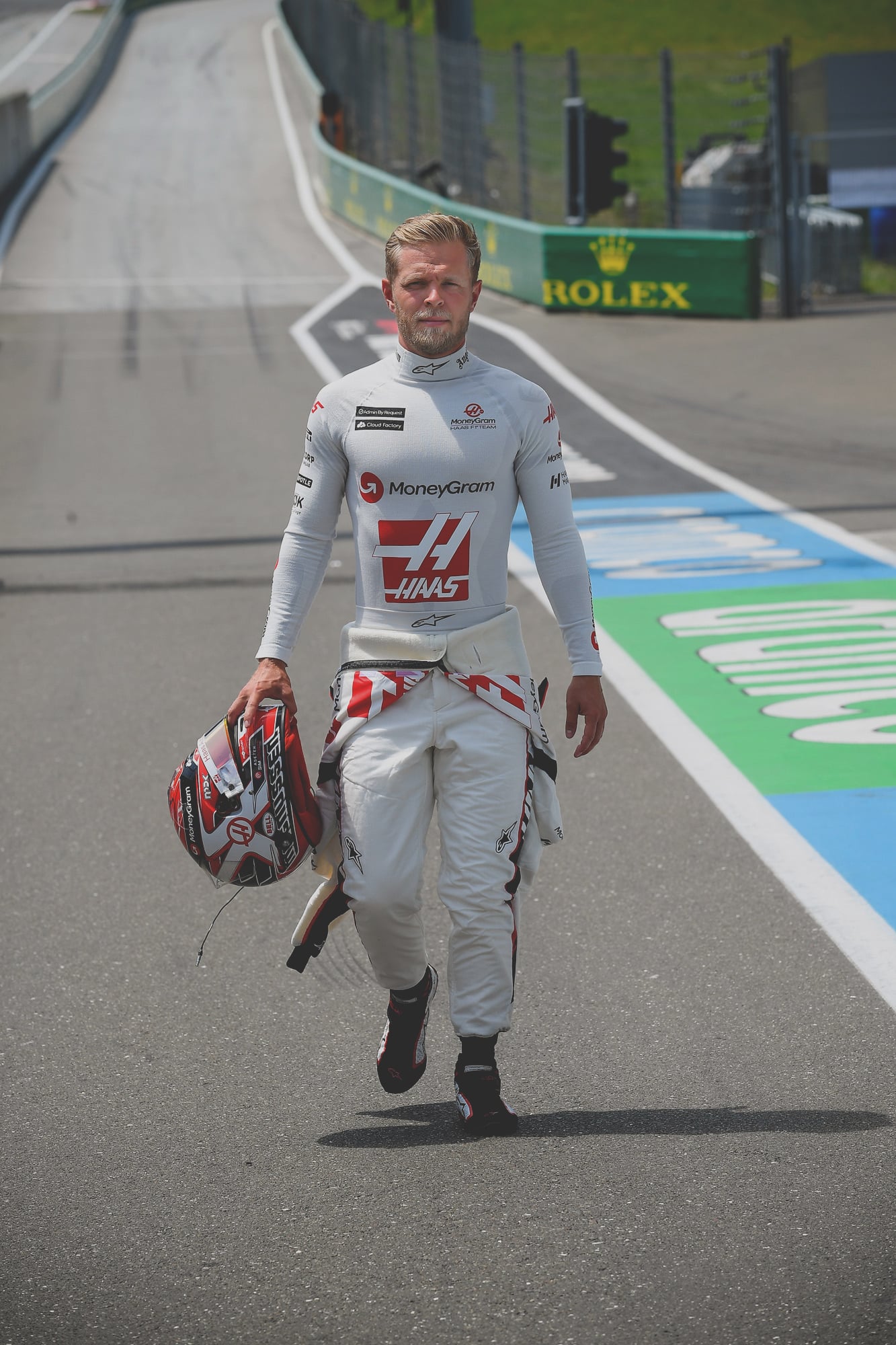 Kevin magnussen walking at the austrian grand prix holding his helmet. » admin by request » admin by request