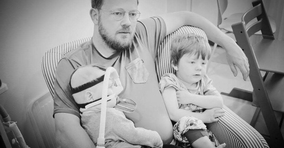 Black and white image of a man with two children.